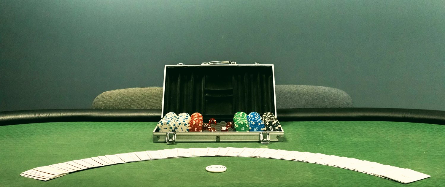 Mesa de poker com fichas coloridas e cartas sobre o feltro verde, em tom claro e vibrante